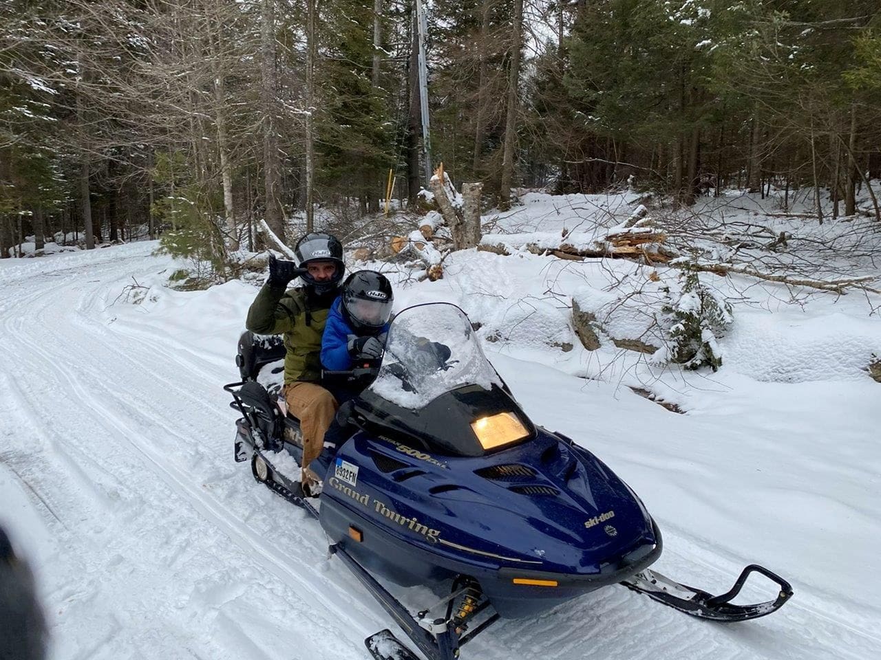 A man riding on the back of a blue snowmobile.