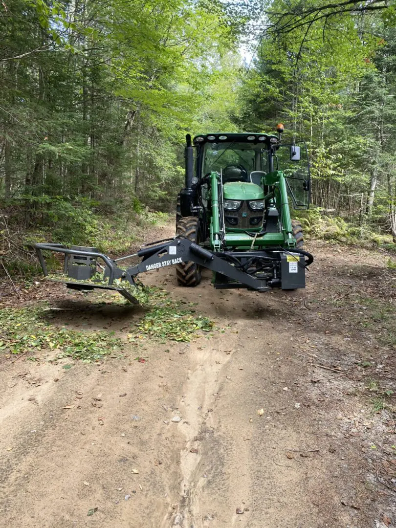 A tractor is cutting through the forest.